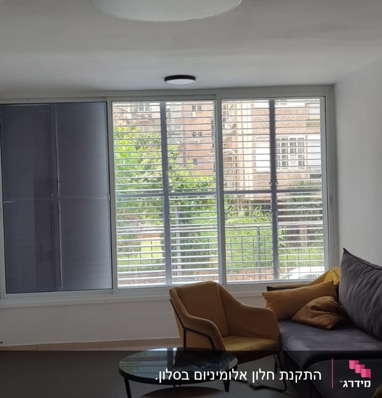 חלון עם תריסי אלומיניום בסלון מואר